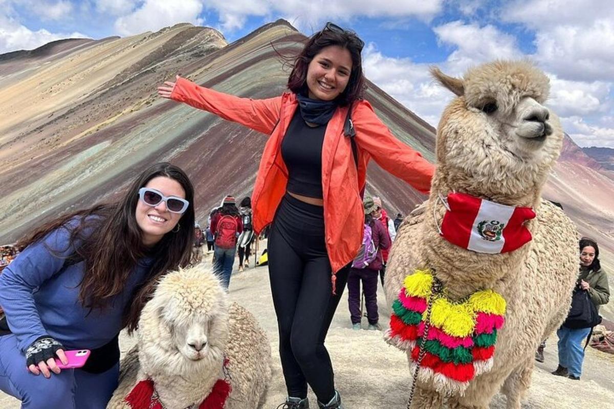 due donne in piedi accanto a due lama davanti a una piramide