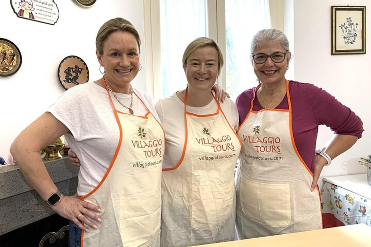 tre donne in piedi in una cucina che indossano grembiuli