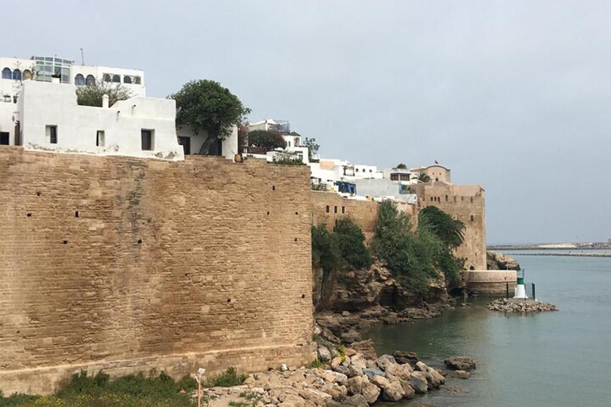 una gran paret de maons al costat d'un riu amb edificis