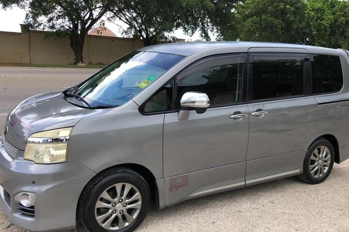 Una camioneta plateada estacionada al costado de una calle