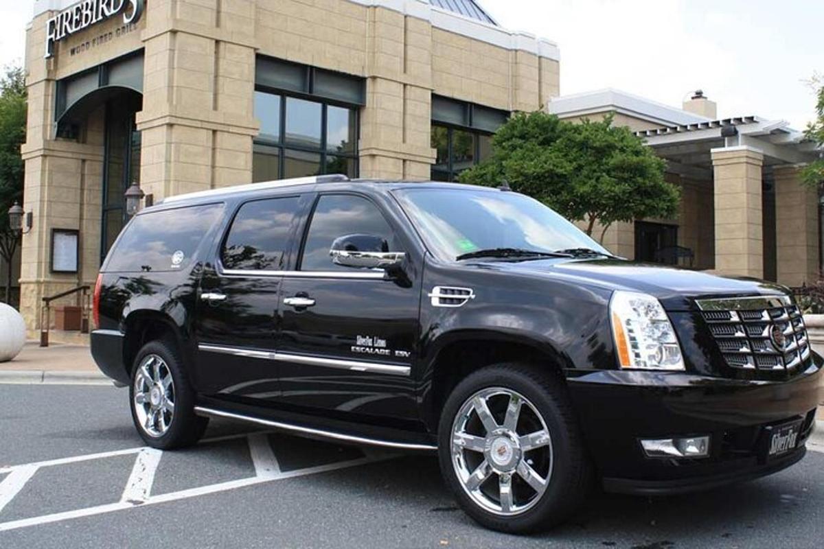 a black truck parked in a parking lot in front of a building