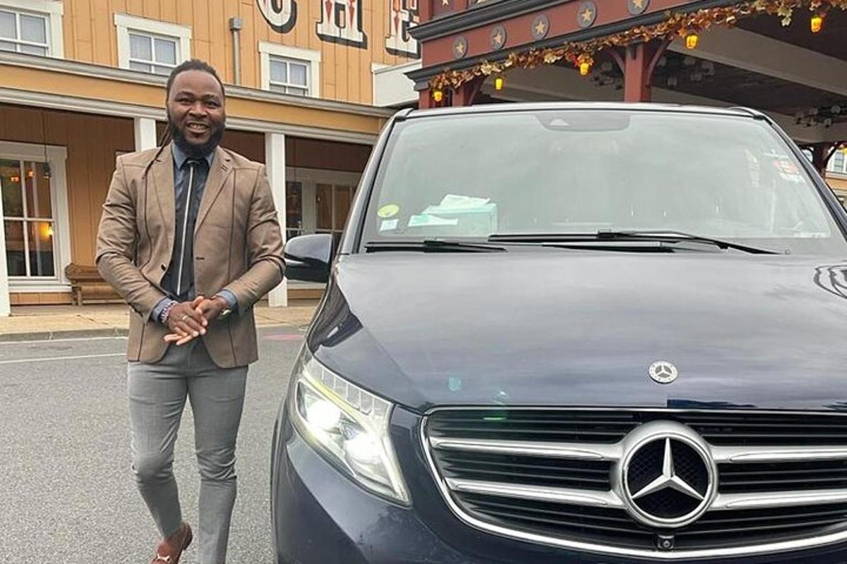 a man in a suit is standing next to a car