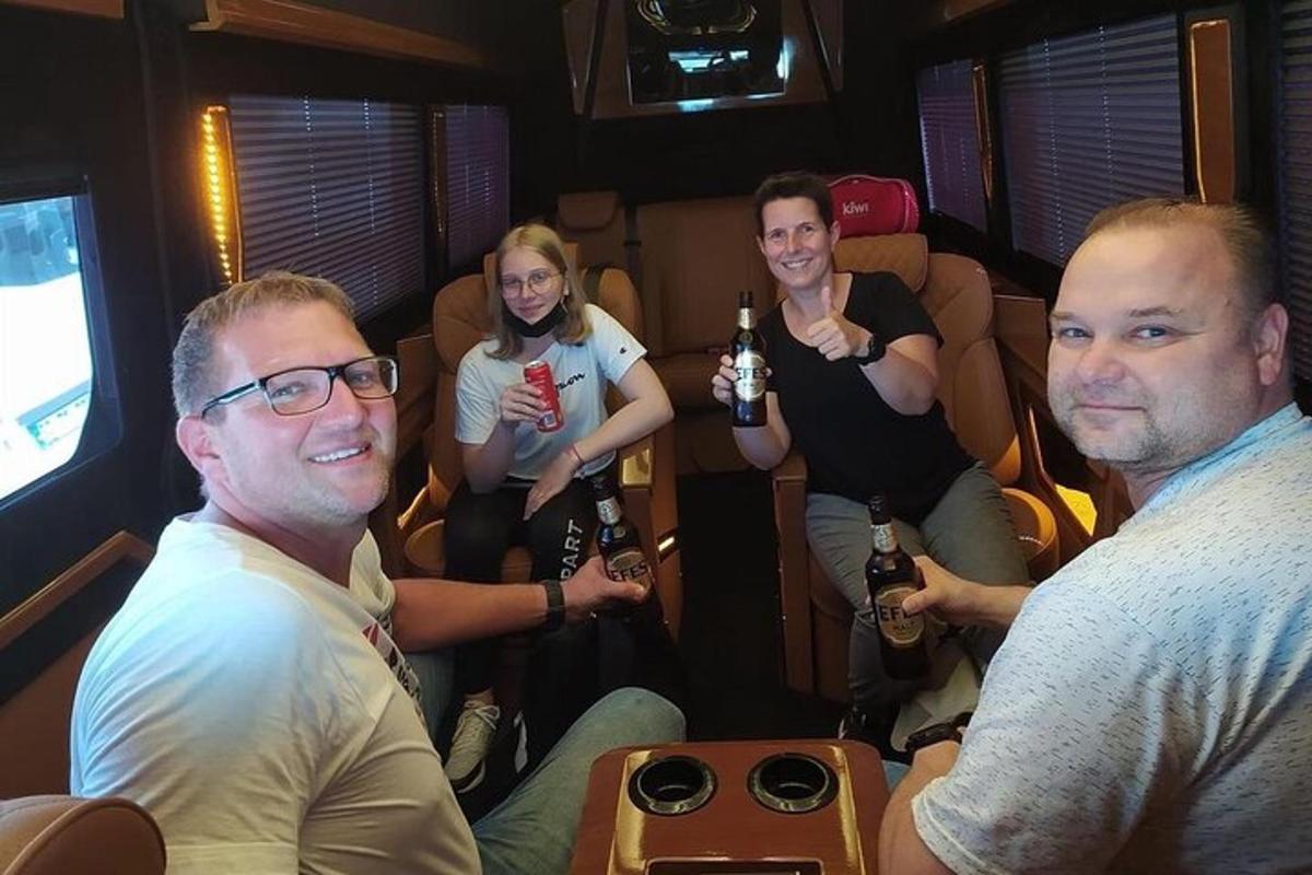 Un grupo de personas sentadas en una camioneta bebiendo cerveza