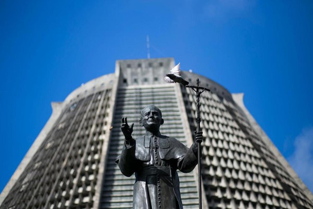 a statue standing in front of a tall building