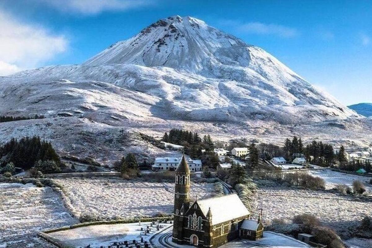 a snow covered mountain with a church in front of a building
