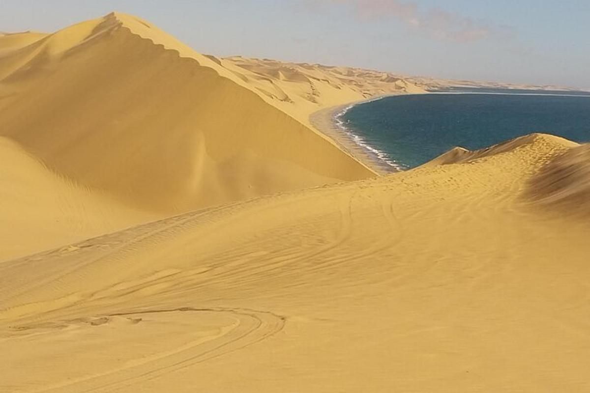 a sand dune in front of a body of water