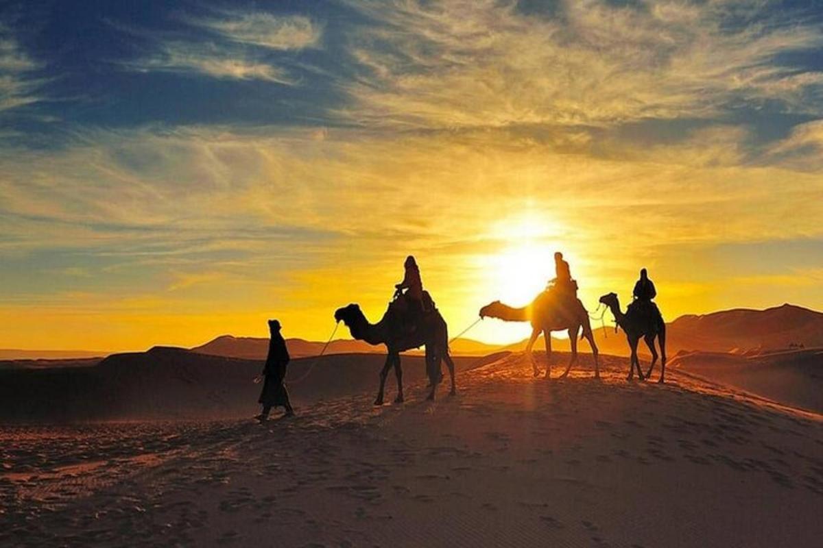 un gruppo di persone a cavallo di cammelli nel deserto