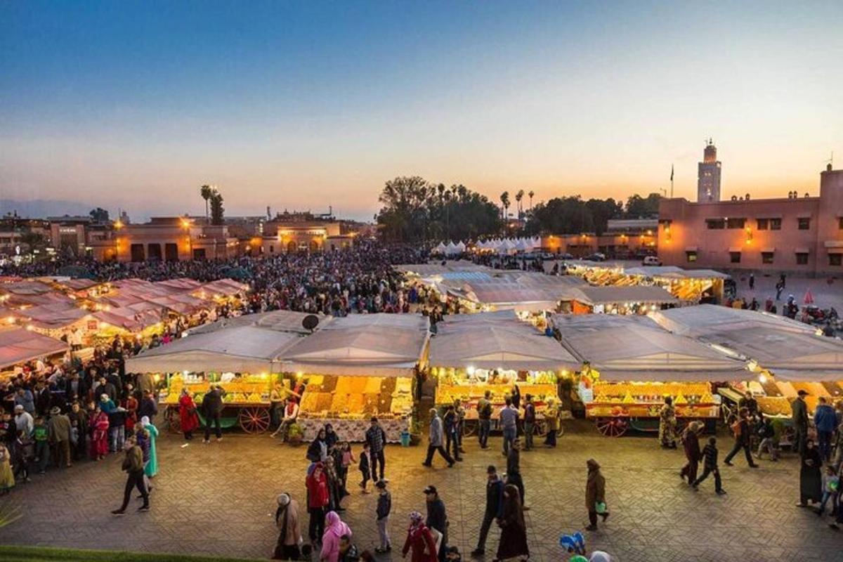 una folla di persone che camminano intorno a un mercato con tende
