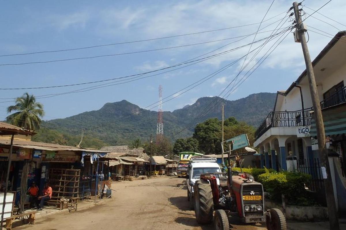 a tractor parked on a dirt road in a village