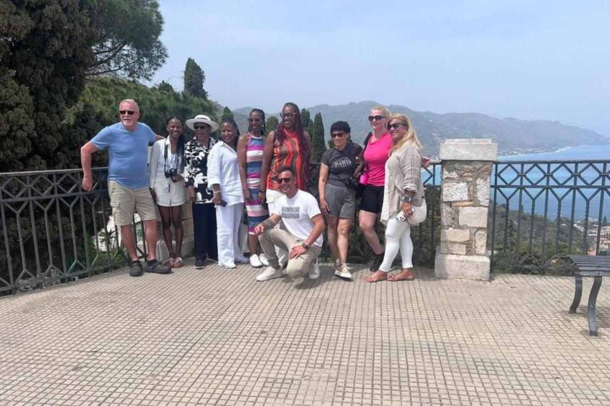 un grup de oameni care pozează pentru o fotografie pe un gard