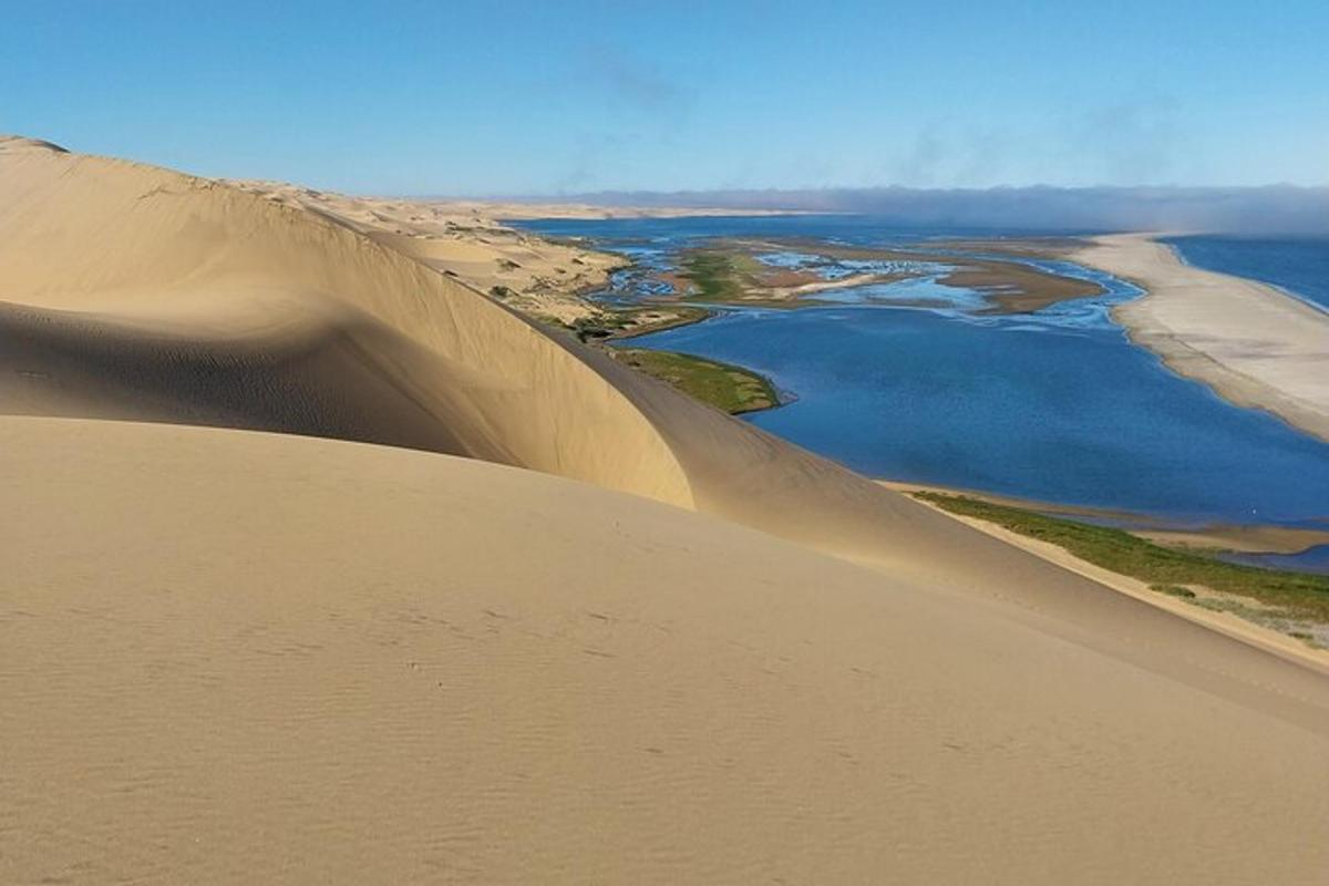 an aerial view of a sand dune with a body of water