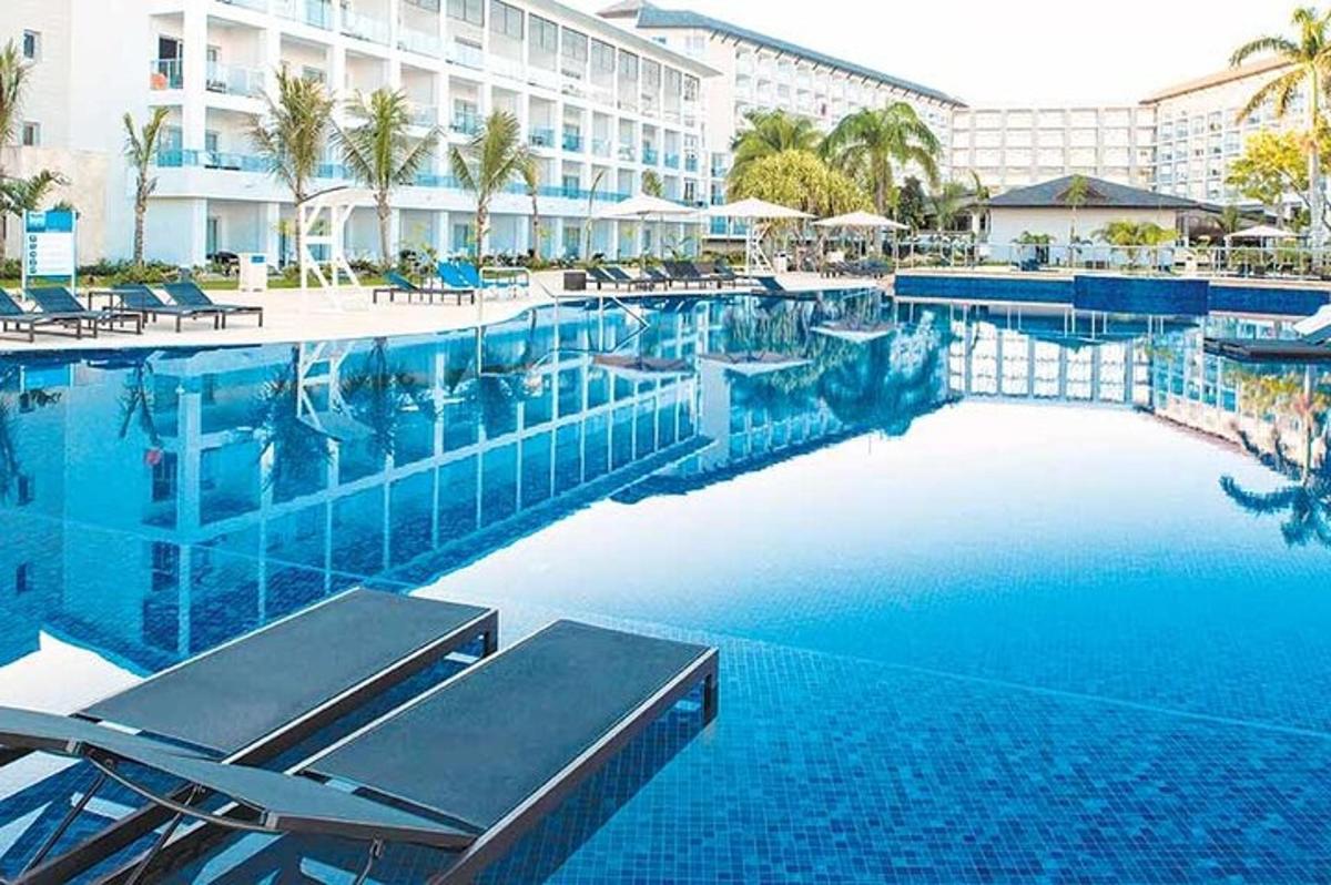kolam renang yang besar dengan kerusi dan hotel