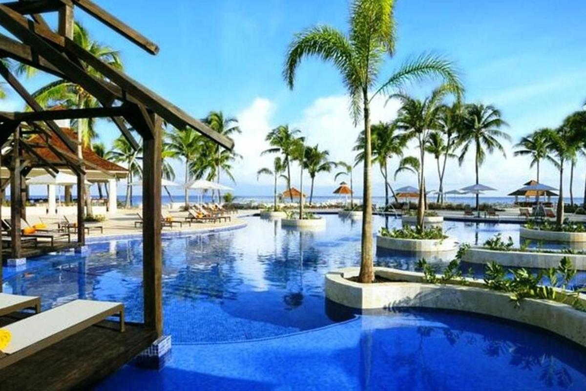kolam renang resort dengan pokok palma dan lautan