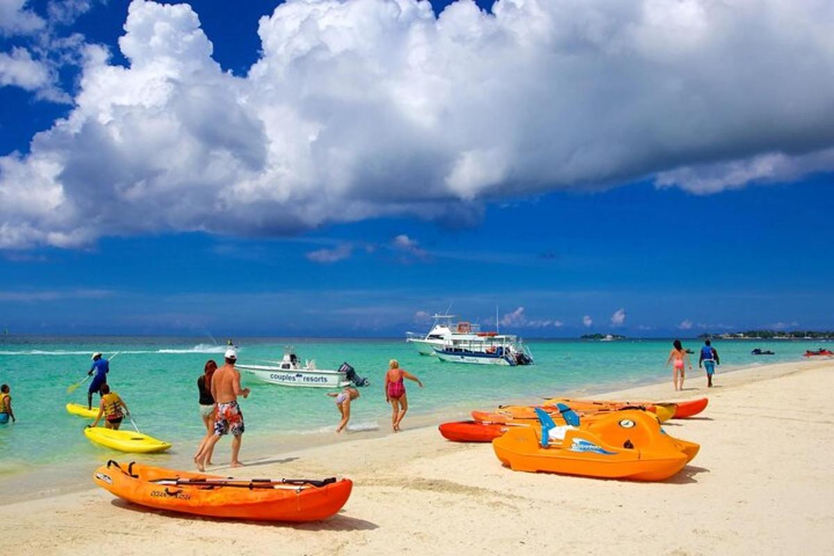 sekumpulan orang di pantai dengan bot di dalam air