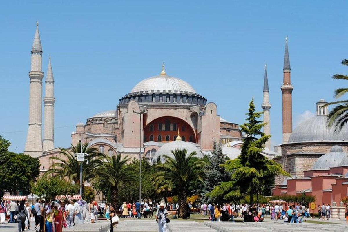 a building with two mosques with people walking in front of it