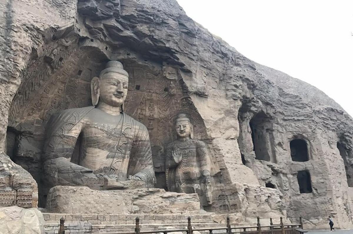 una grande statua di due persone di fronte a un edificio