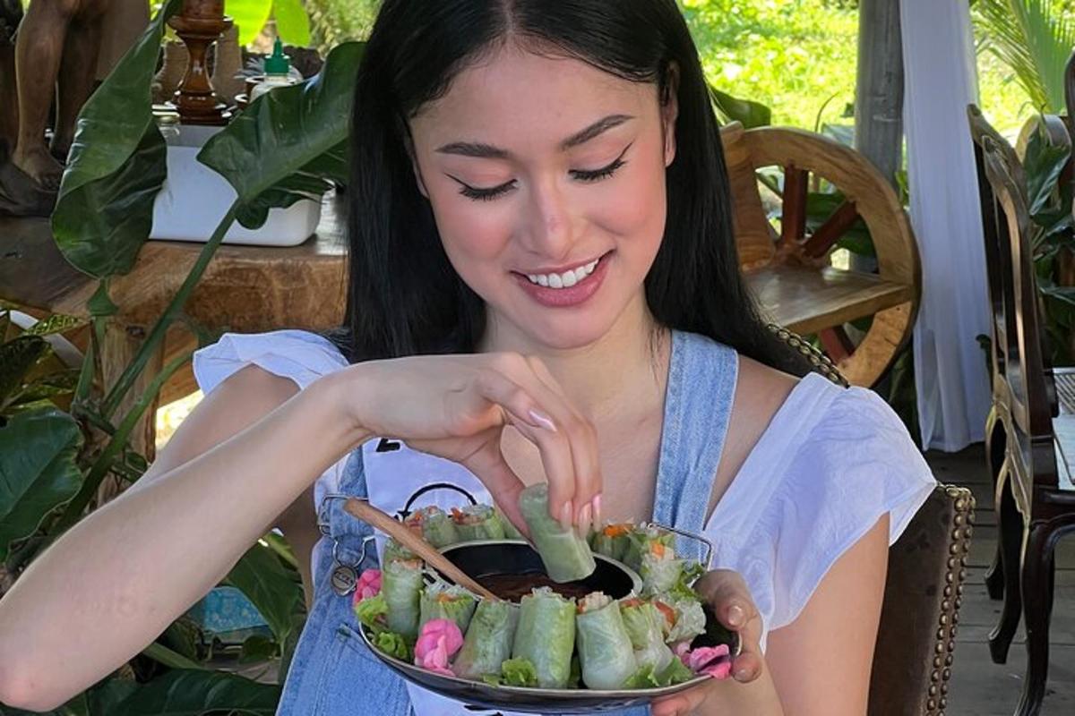 a woman is holding a bowl of vegetables