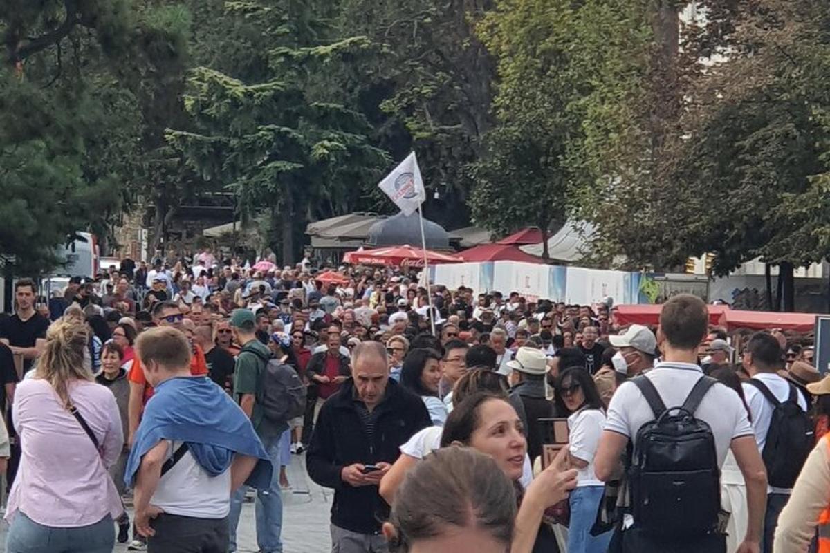 una grande folla di persone che camminano lungo una strada
