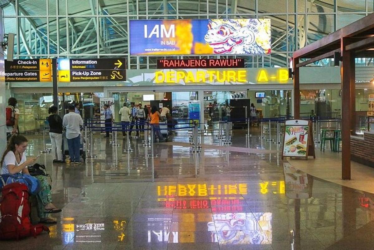 một người phụ nữ đang ngồi giữa sân bay