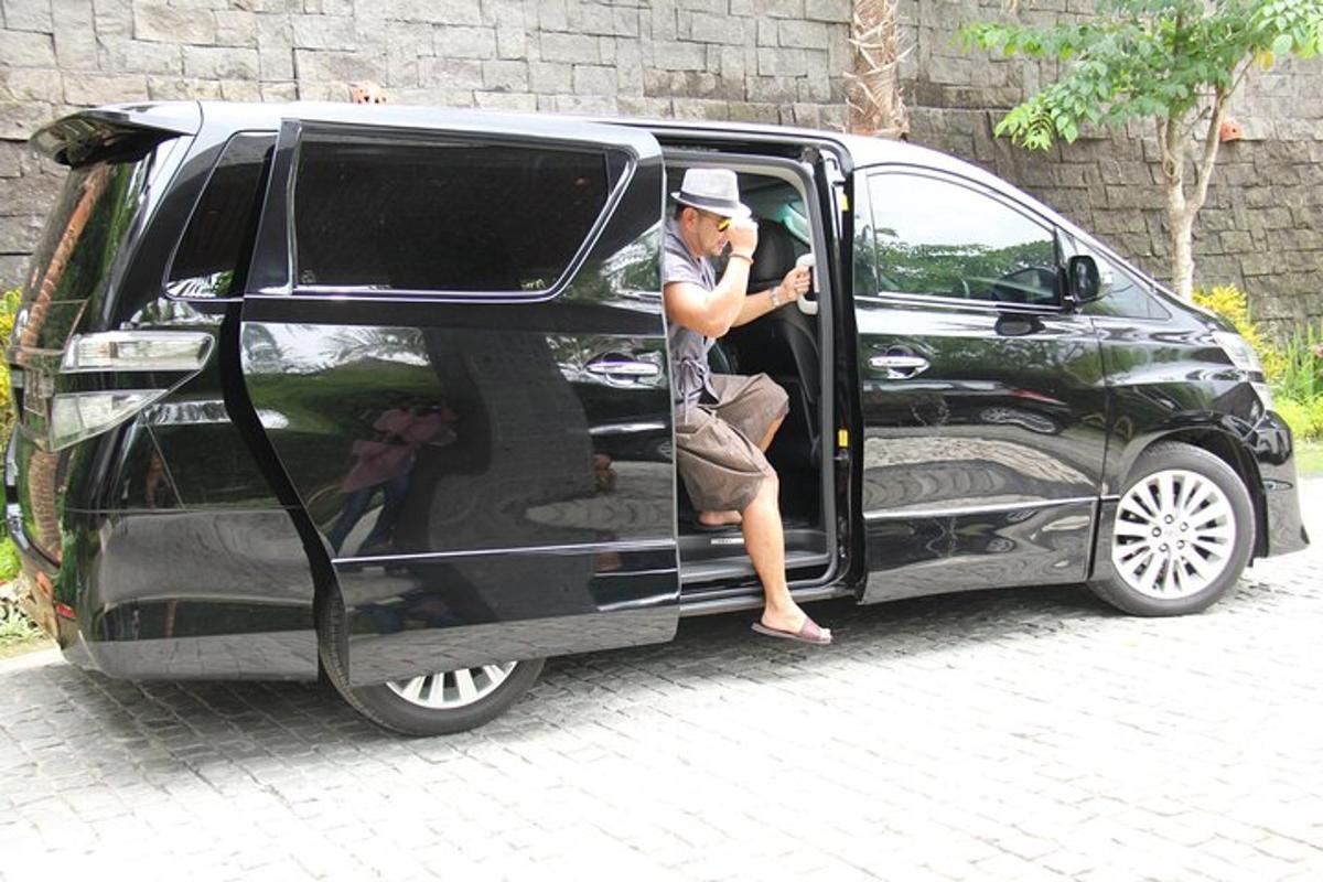 a man sitting in the door of a black van