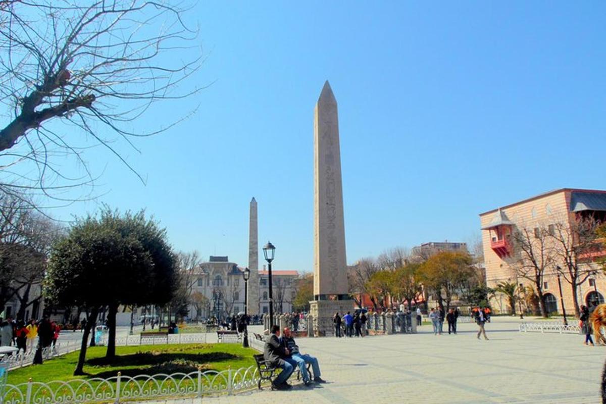un grup de oameni așezați pe o bancă în fața unui monument