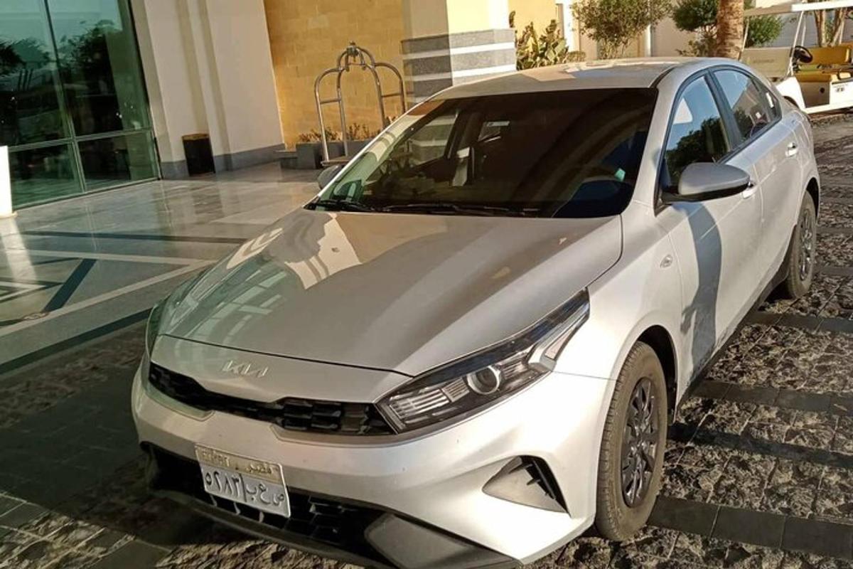 Un coche blanco aparcado delante de un edificio