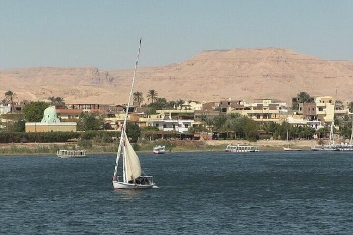 una barca a vela in acqua con una città sullo sfondo