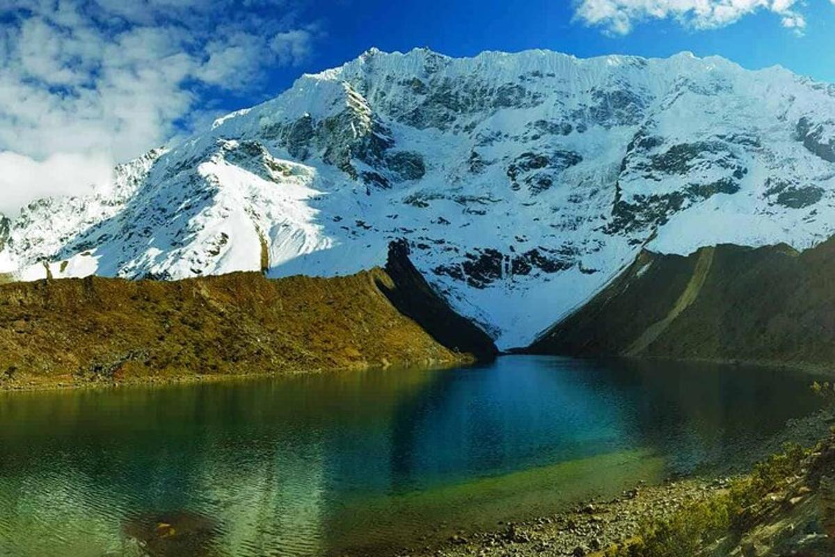 una muntanya coberta de neu amb un llac al davant