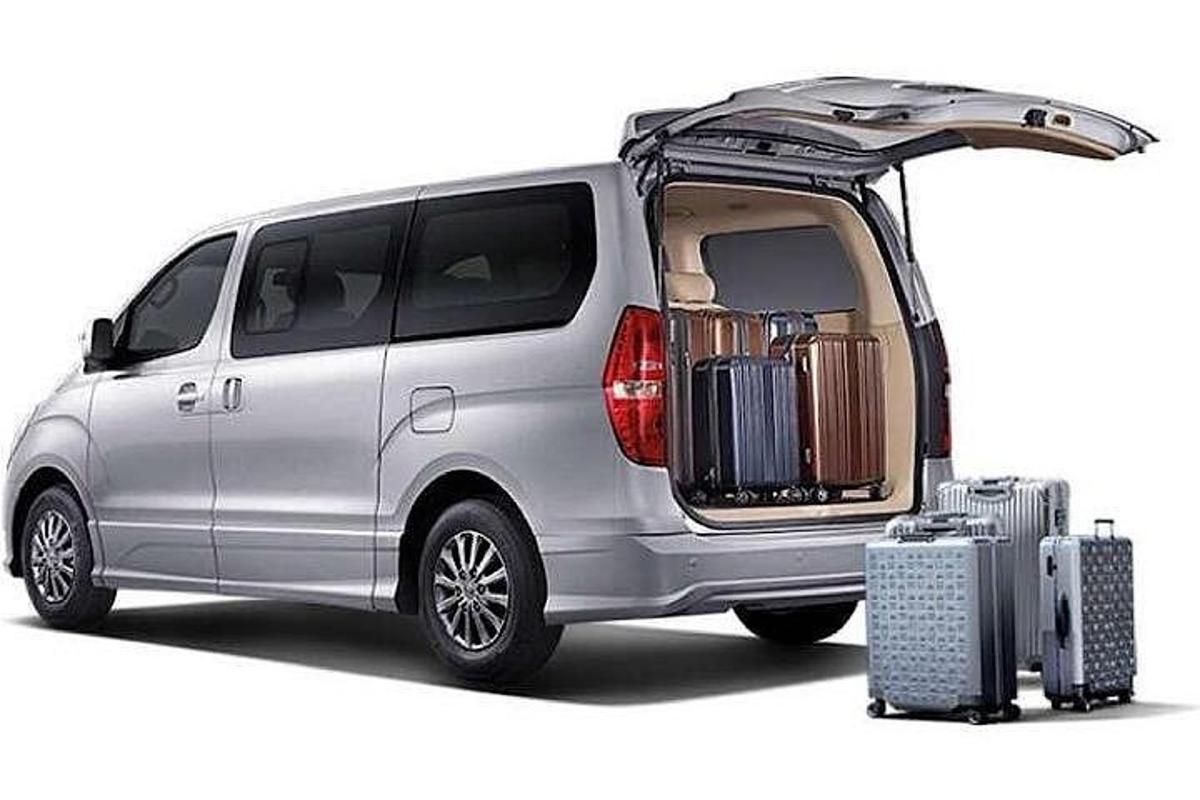 a silver van with its back open with its luggage