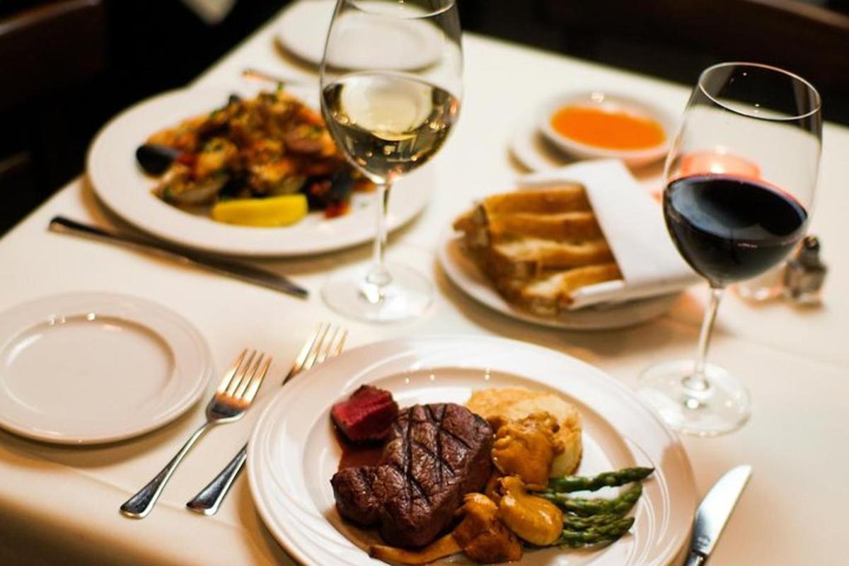a table with plates of food and glasses of wine