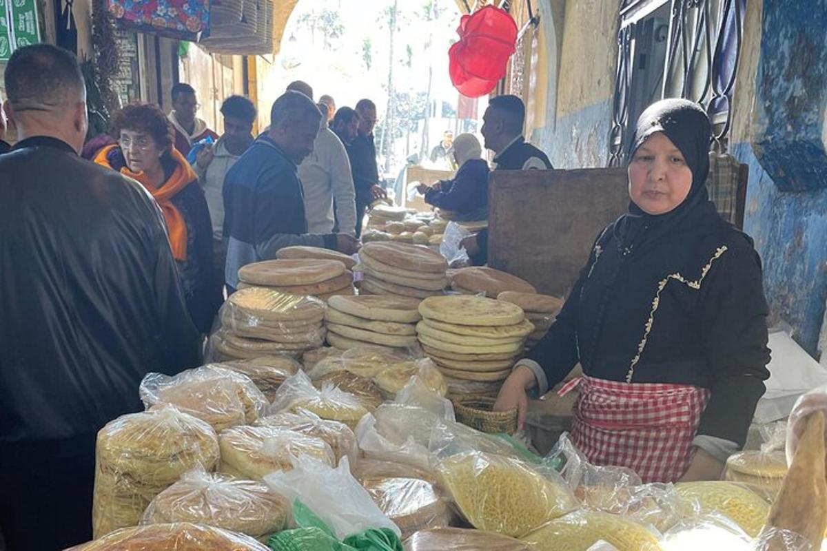 一名妇女站在市场前，手里拿着食物