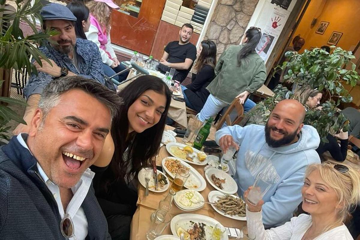 skupina lidí sedících u stolu a jedících