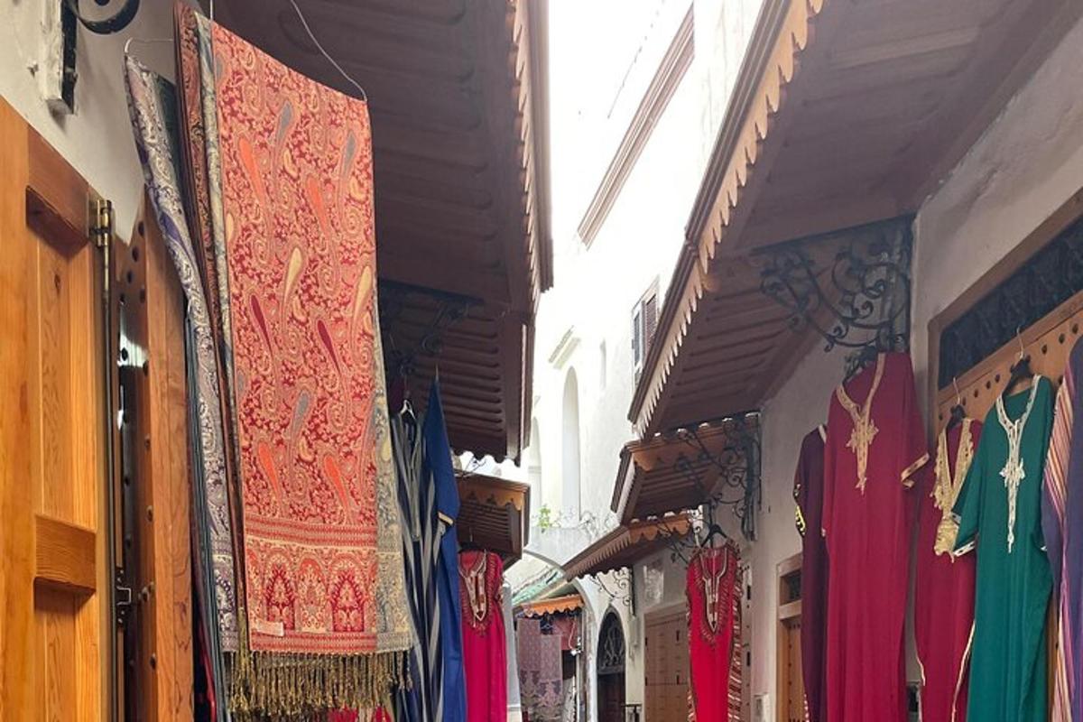 ένα μαγαζί με πολύχρωμα χαλιά κρεμασμένα στον τοίχο