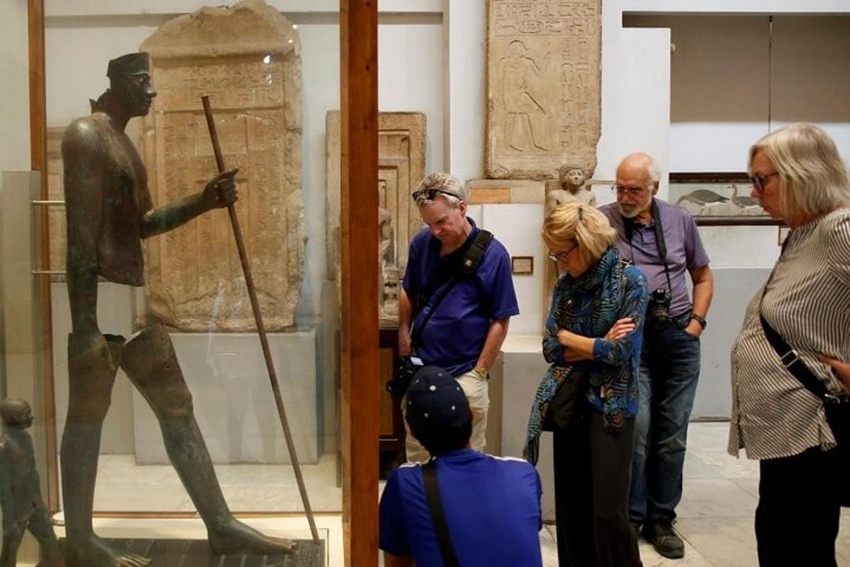 μια ομάδα ανθρώπων που κοιτάζει ένα άγαλμα σε ένα μουσείο