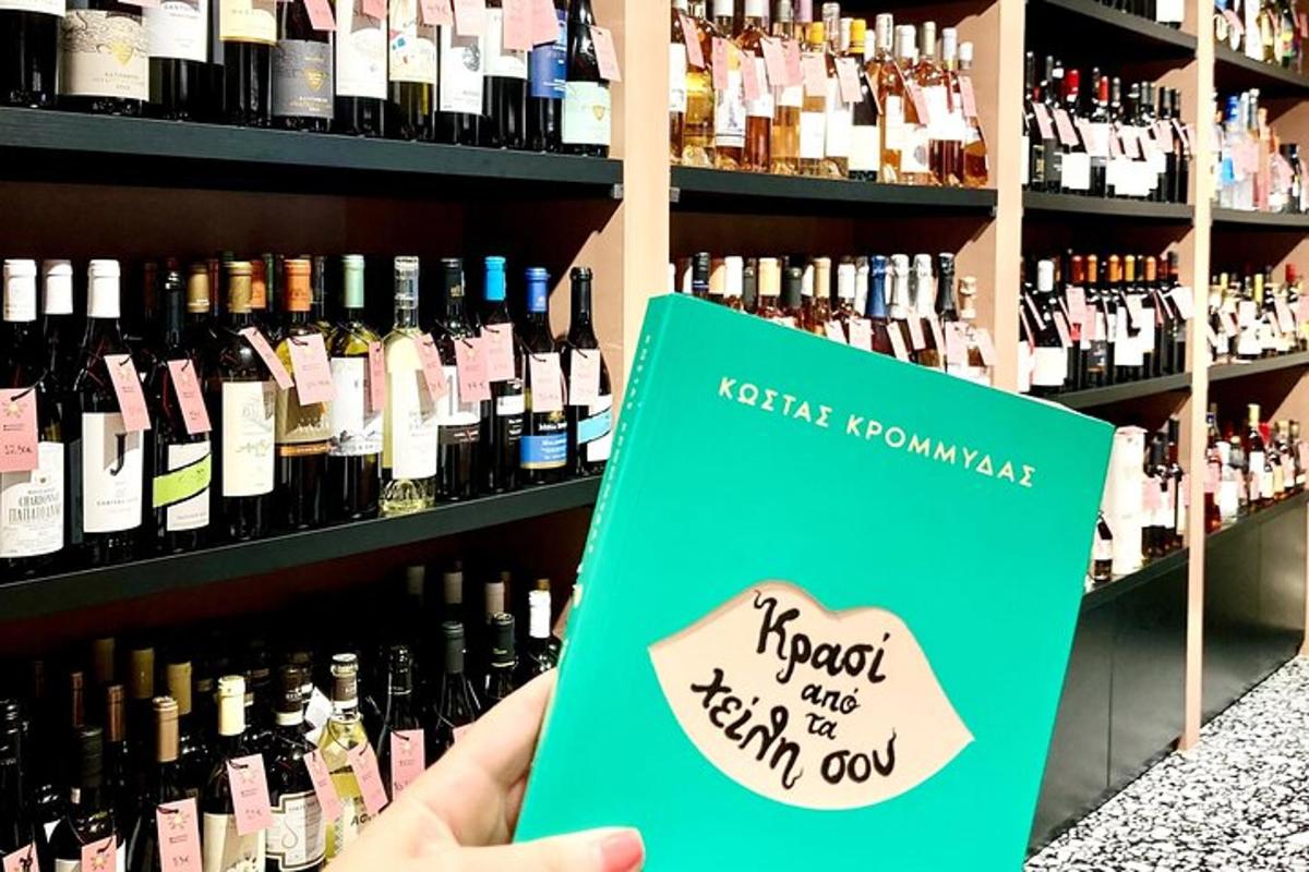 en person som holder en bok foran vinflasker