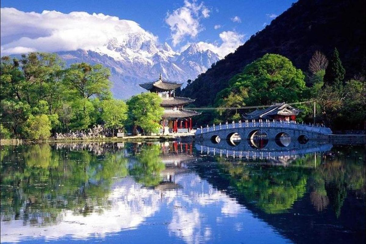 a bridge over a lake with a mountain in the background