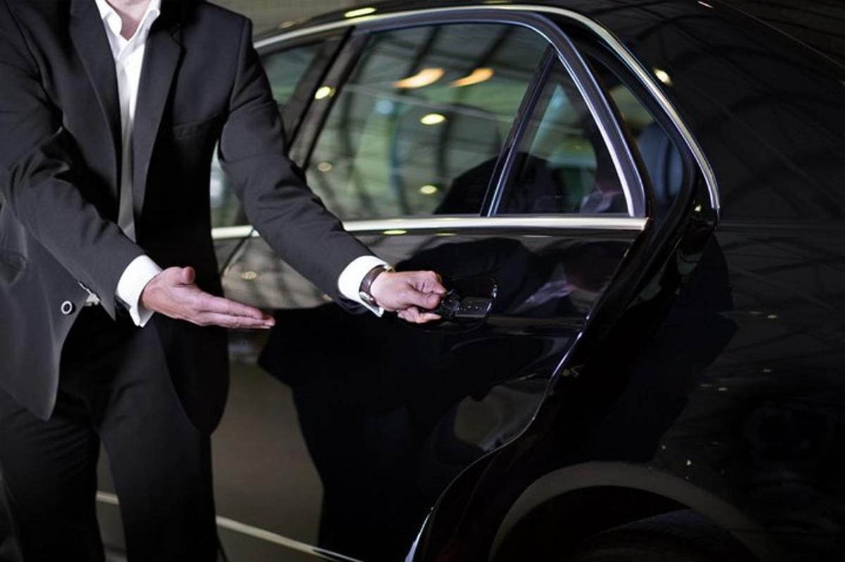 a man in a suit standing next to a car