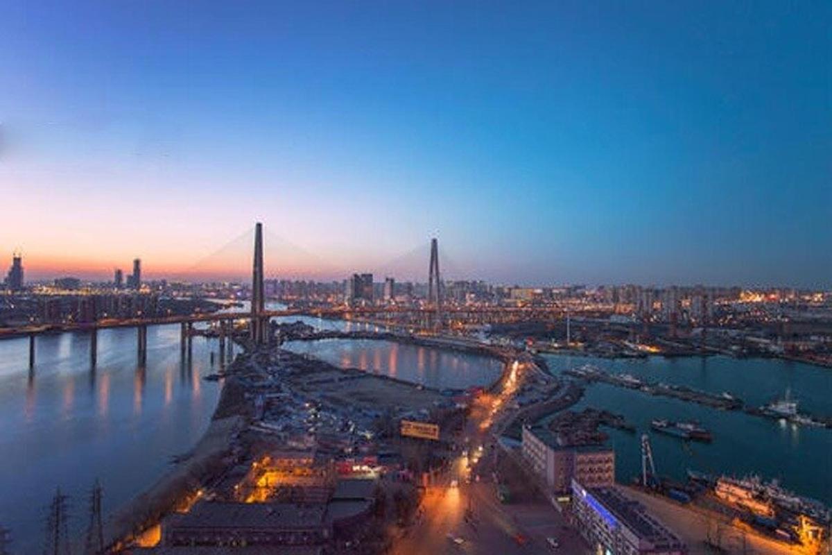 a city with a bridge over the water at night