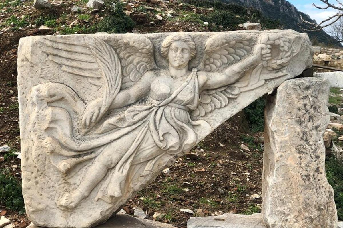 a statue of an angel sitting on a rock