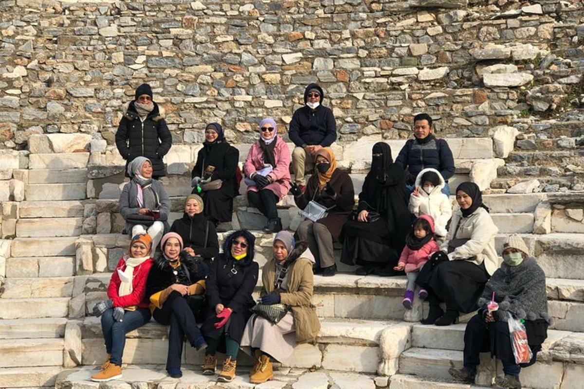 a group of people sitting on steps in front of a stone wall