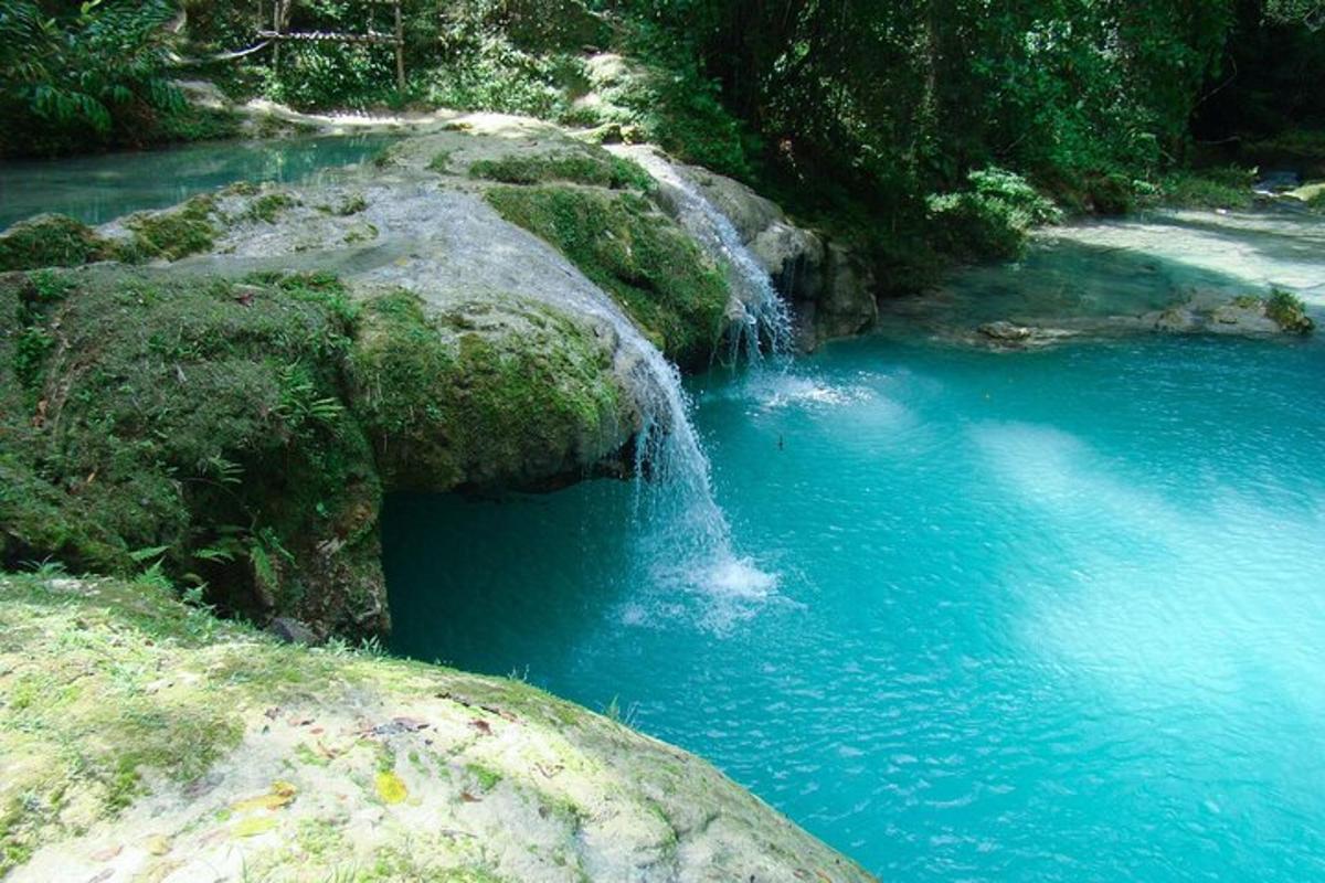 una cascada en medio de un río azul