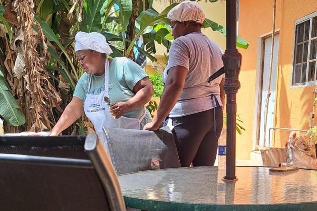 dalawang babaeng nakatayo sa tabi ng mesa