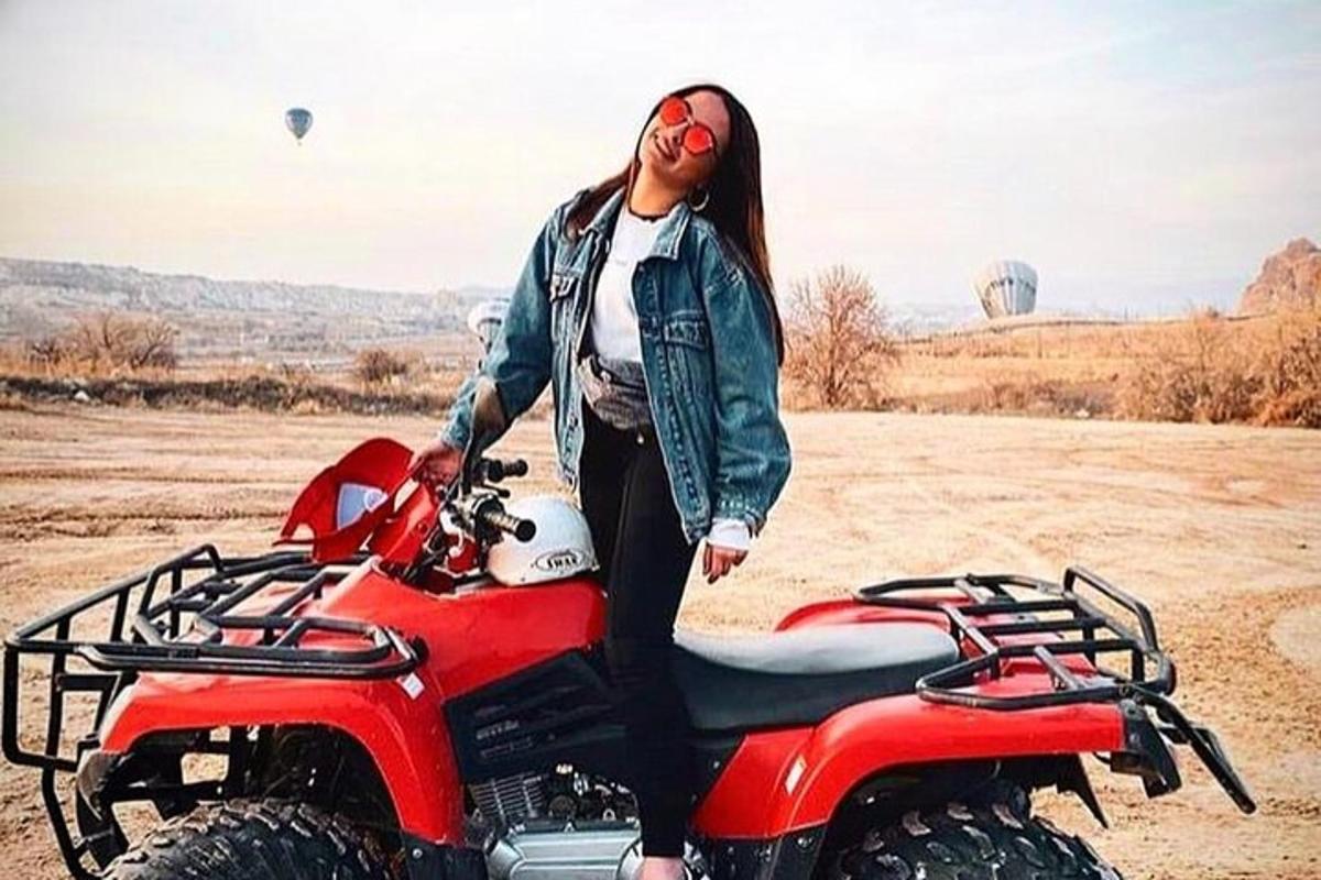 žena stojící vedle červené terénní motorky