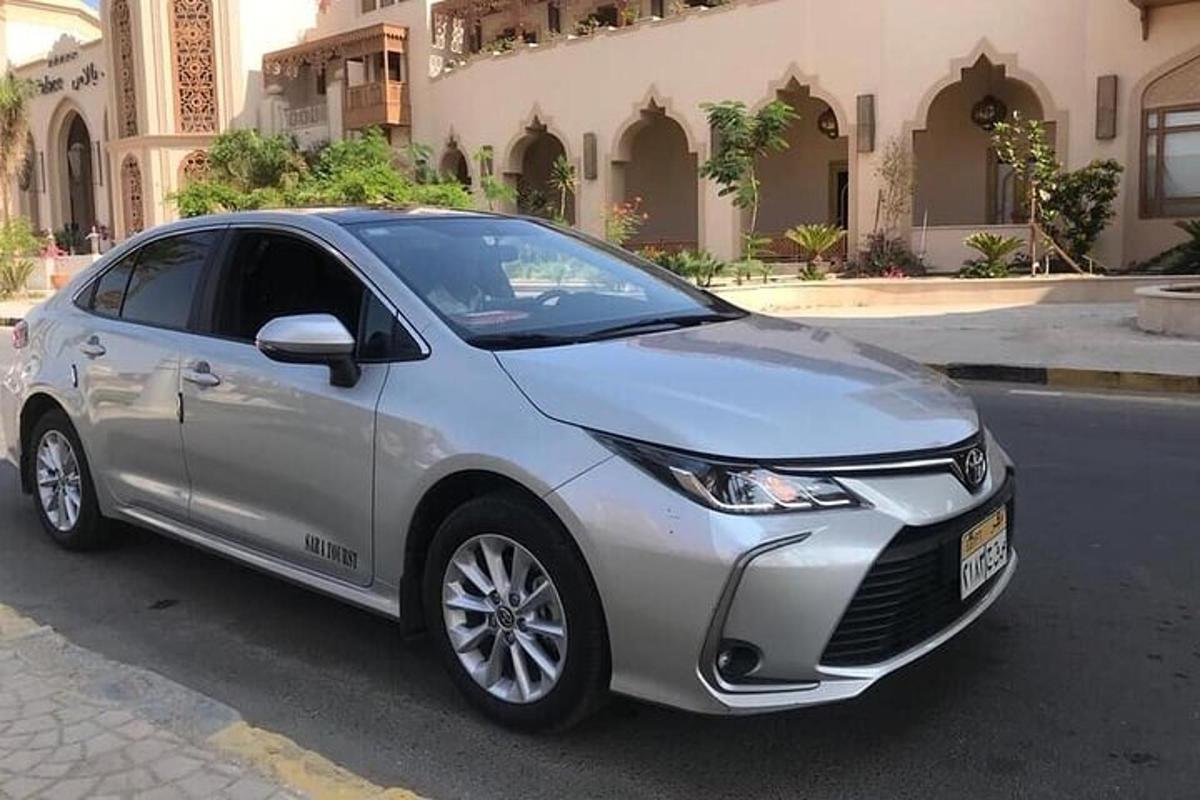 un Toyota Olla platejat aparcat davant d'un edifici