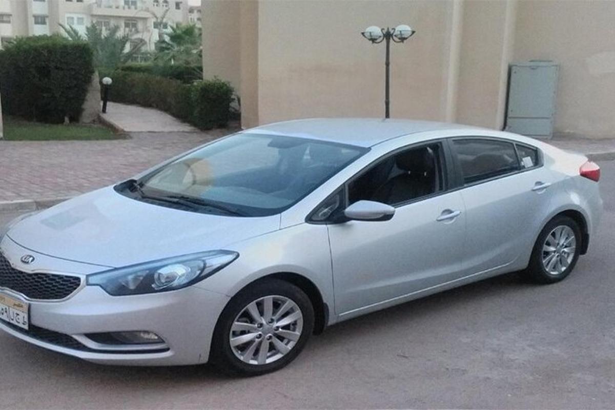 Un coche plateado aparcado delante de un edificio.