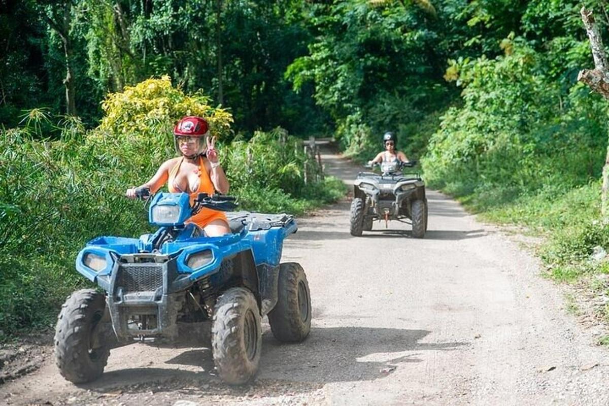 duas pessoas andando de quadriciclo em uma estrada de terra