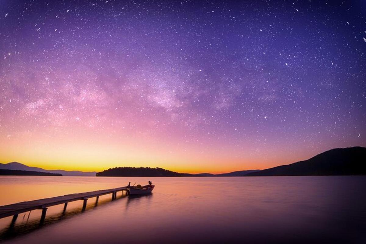 a boat on the water under a starry sky