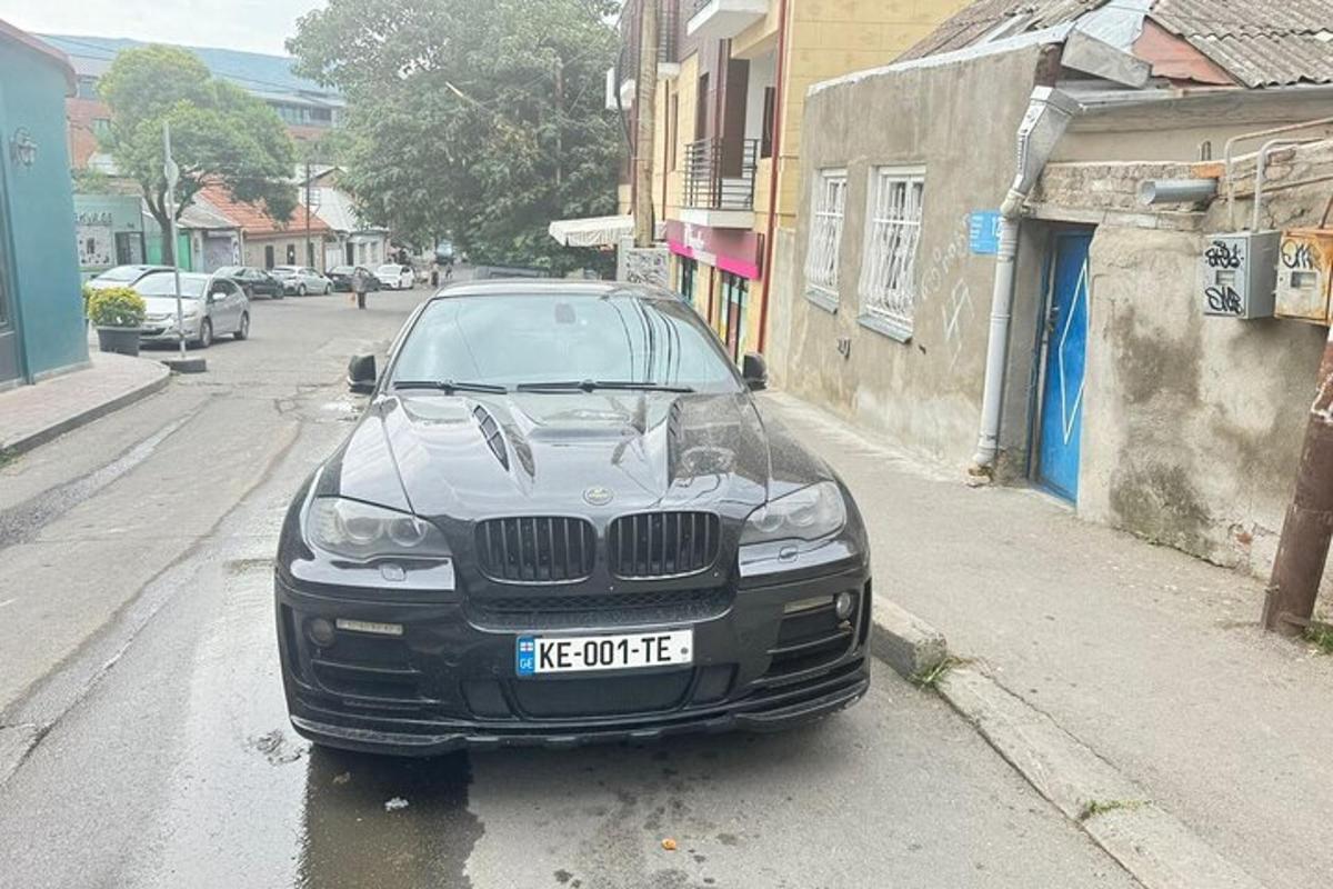 un'auto nera parcheggiata sul ciglio di una strada