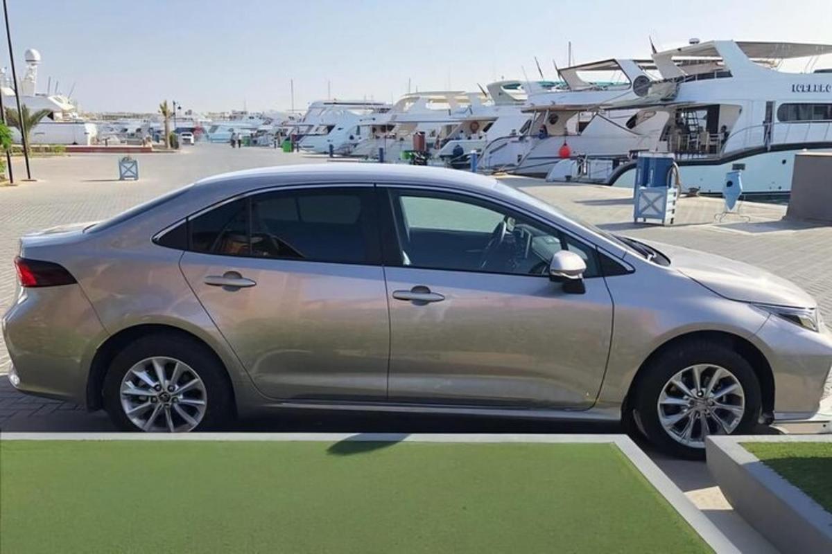 strieborné auto zaparkované na parkovisku s loďami