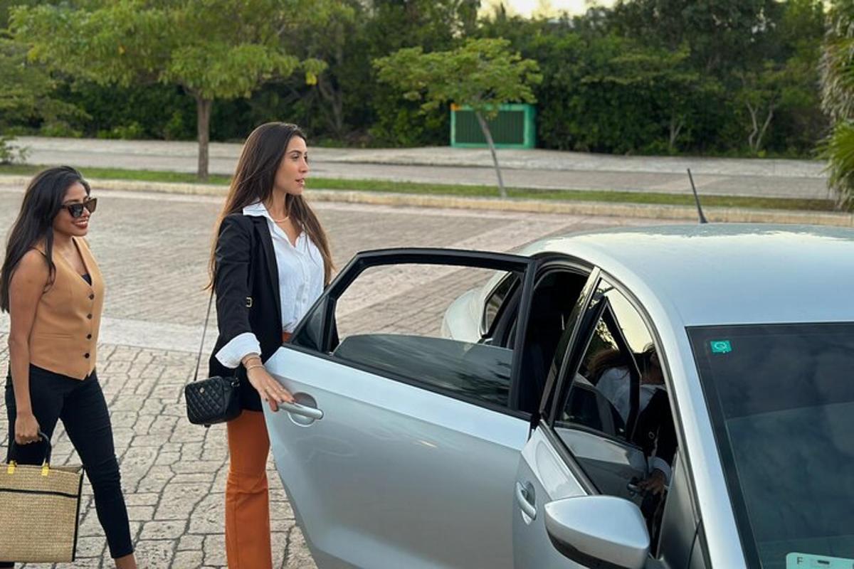 hai người phụ nữ đang đứng cạnh một chiếc xe hơi